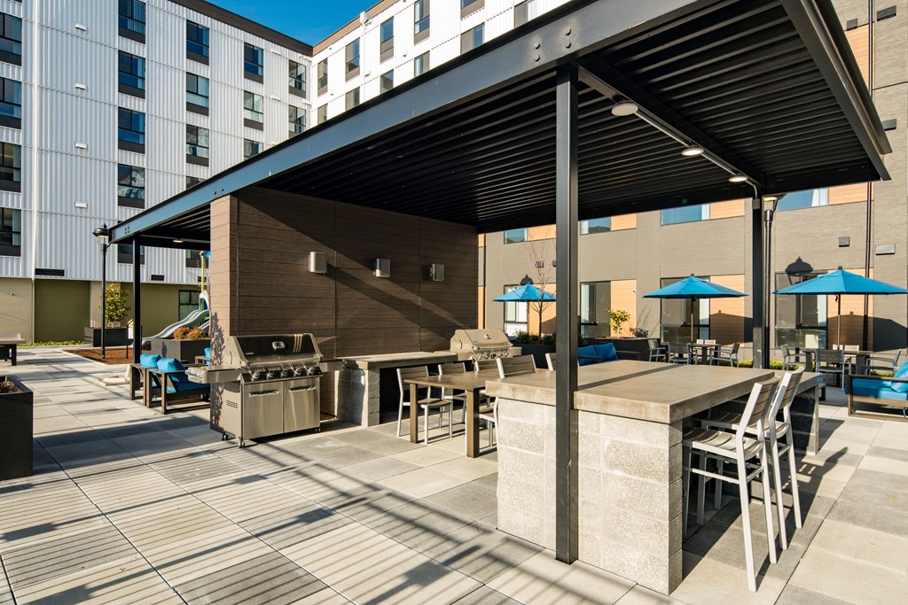 Covered courtyard with picnic area seating, bbq grills and lounging area.