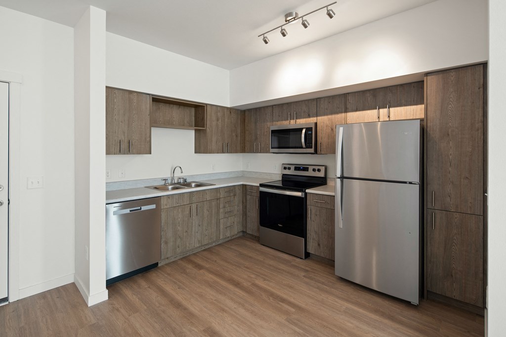 Full kitchen with stainless steel fridge, range oven, dishwasher and microwave