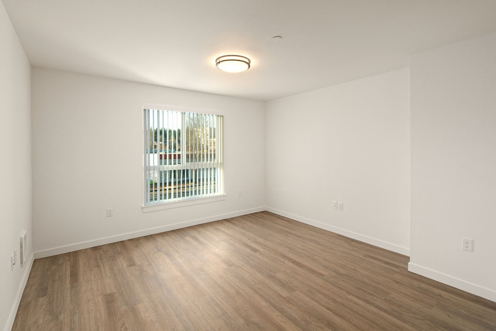 Spacious floor plan with large window and hardwood floors