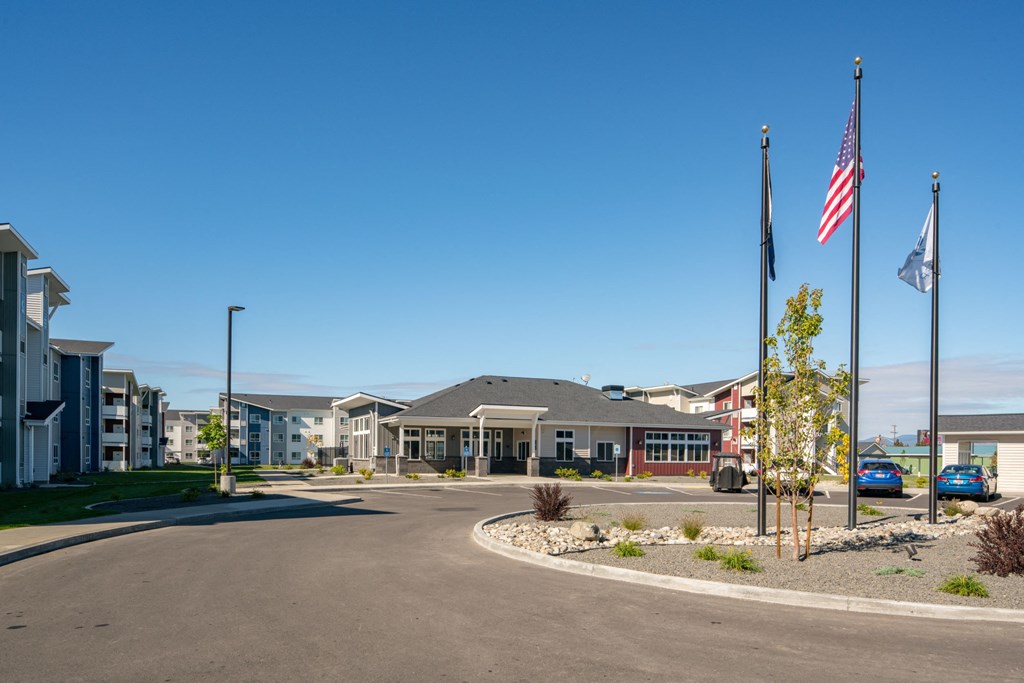 an empty parking lot flags in front of a building