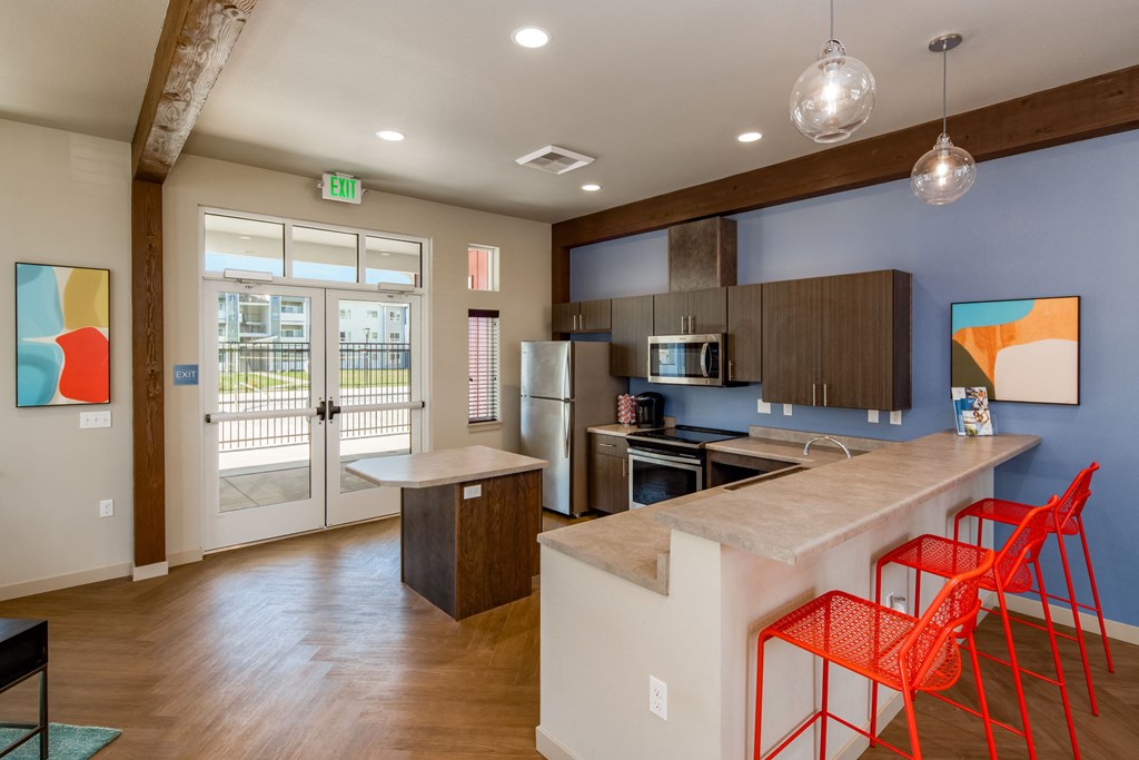 a kitchen with a bar and chairs in front of a door