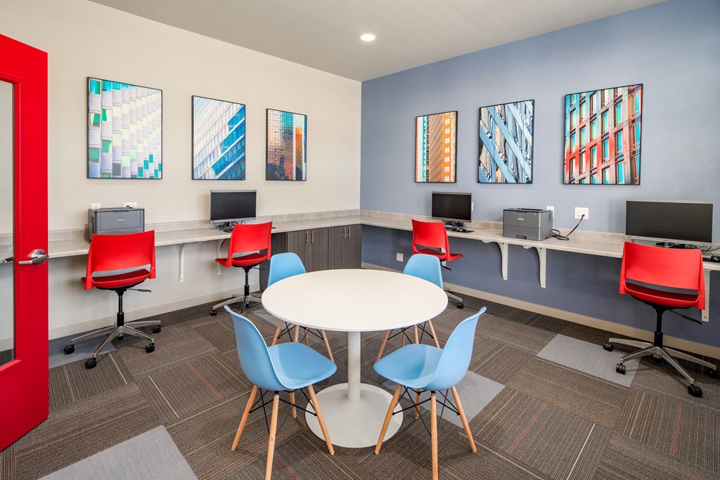 a room with a table and chairs and computers