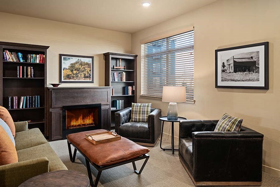 Seating by fireplace and bookshelves at TRADITIONS AT LAFAYETTE Apartments, LAFAYETTE , CO 80026