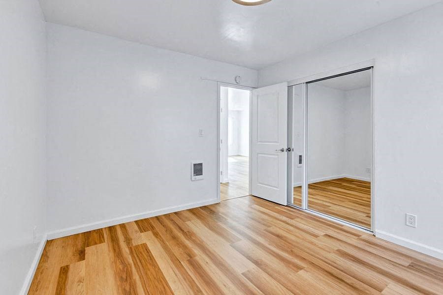 Bedroom with wood floors and closet