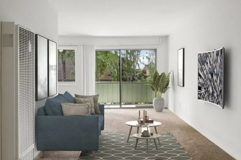 A living room with a grey couch and a large window.