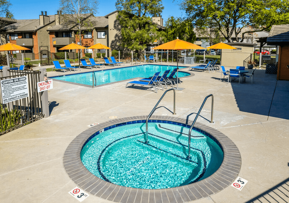 Pool with lounge chairs and umbrellas and spa