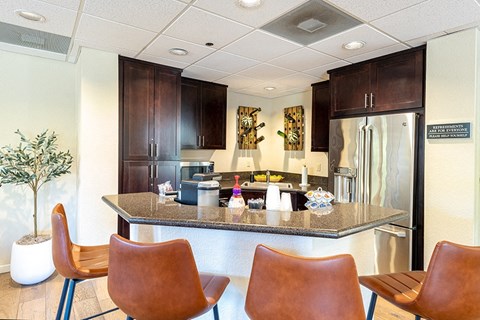 a kitchen with a granite counter top and a stainless steel refrigerator