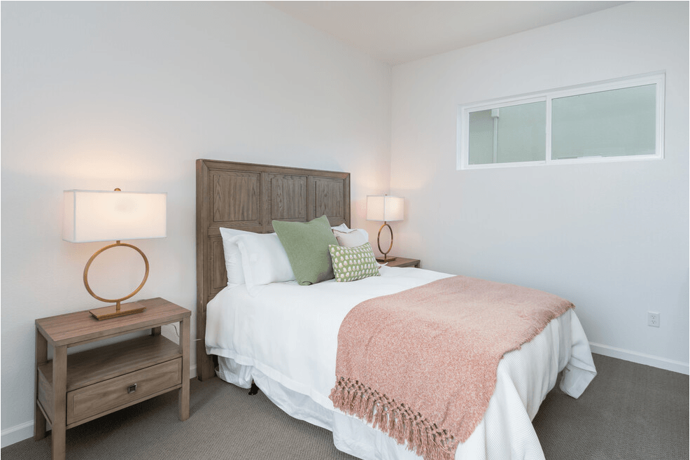 a bedroom with a bed and a nightstand with two lamps