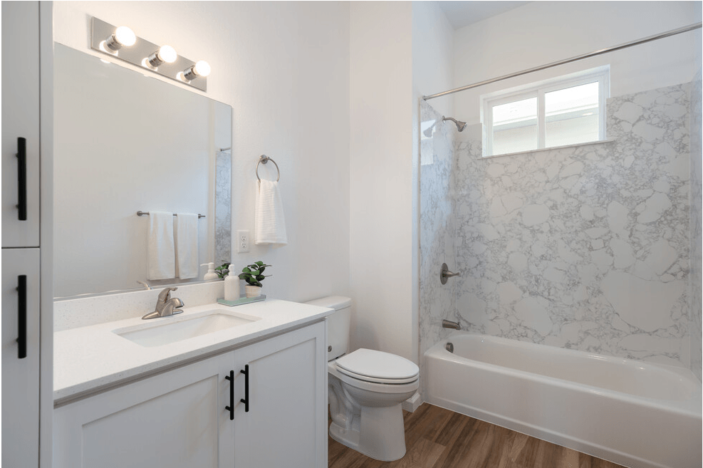 a bathroom with a white sink and toilet next to a white bathtub