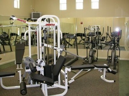 A gym with a variety of equipment including a leg press machine.