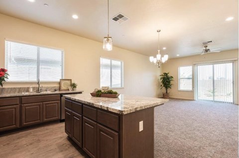 A kitchen with brown cabinets and a marble countertop.