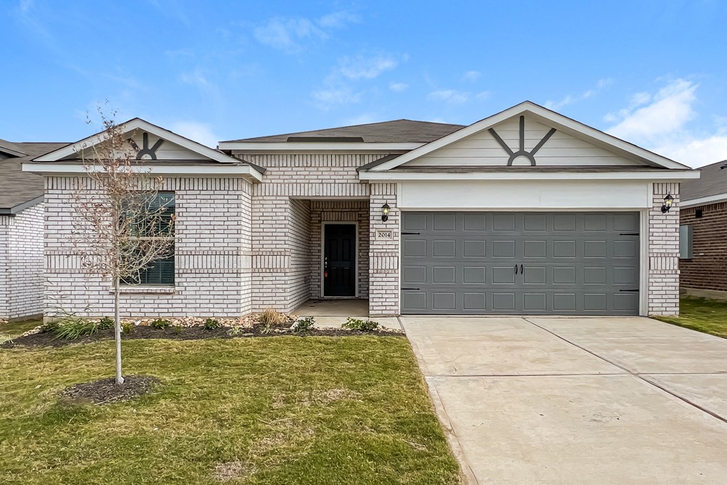 a white brick house with a gray garage door
