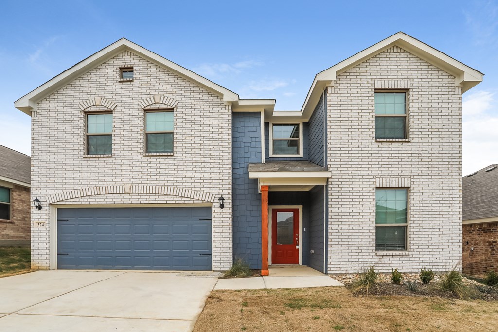 a white brick house with a blue garage door