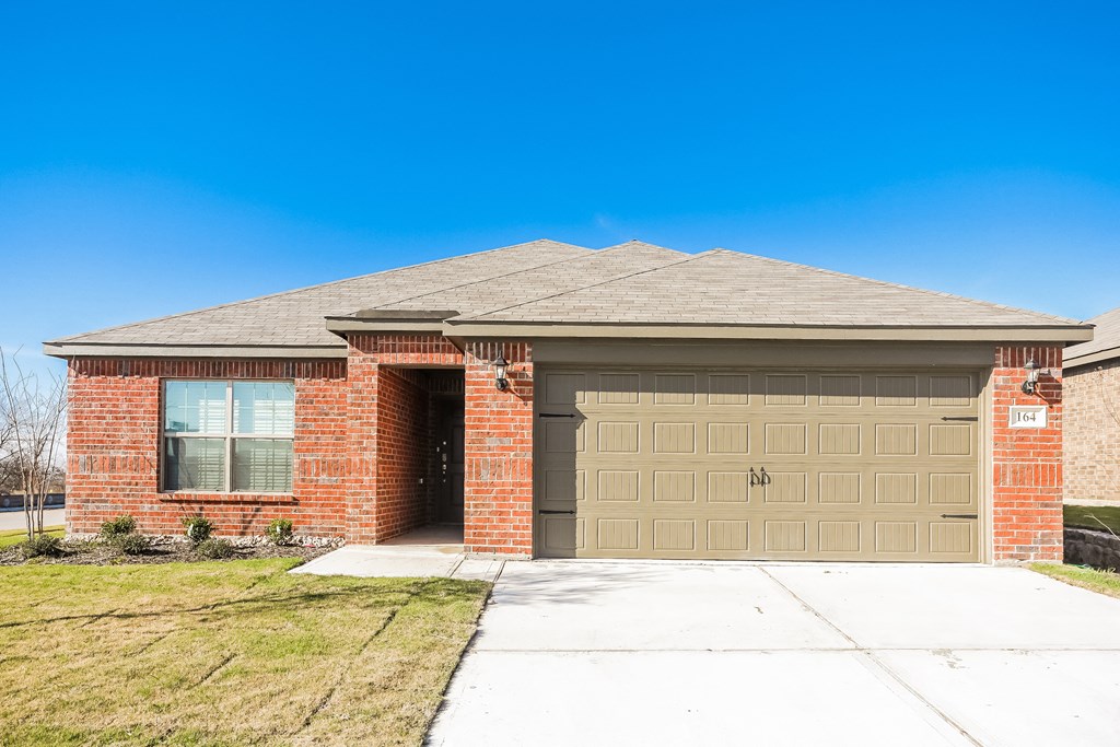 a brick house with a brown garage door