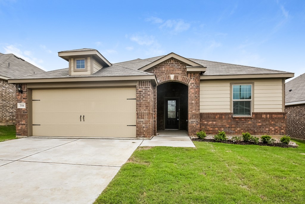 a tan house with a driveway and a garage door