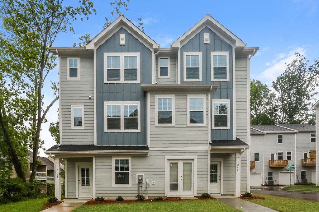 the view of a large house with a sidewalk in front of it