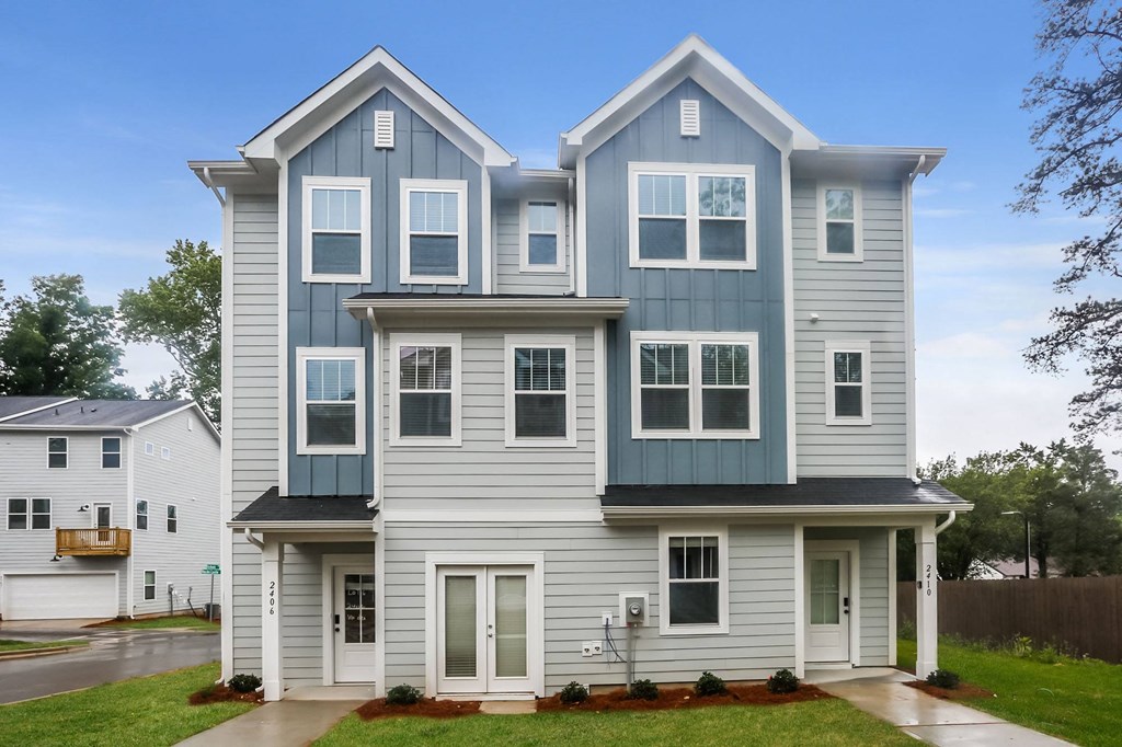 a blue and white house with a sidewalk in front of it