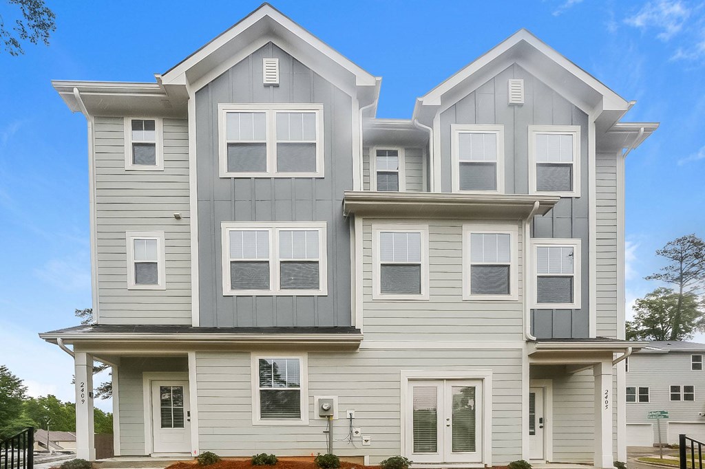 a white and gray house with a blue sky in the background