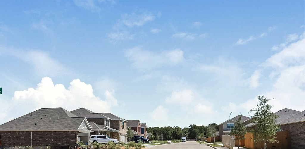 A row of houses with a car parked in front of them.