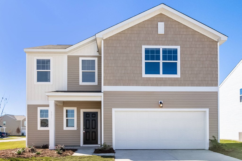 a tan house with a white garage door