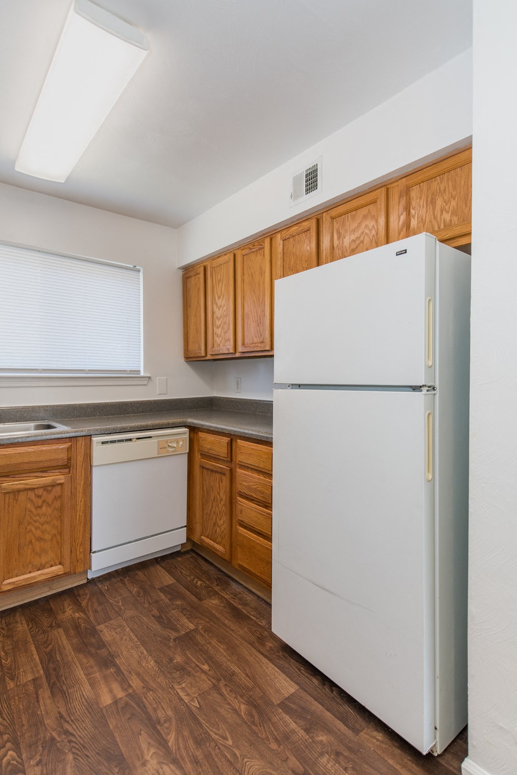 a kitchen with wooden cabinets and a white refrigerator
