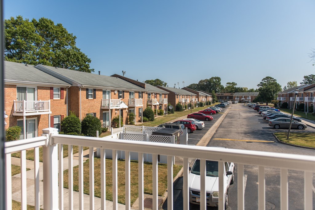 the view from a balcony of a row of town homes with cars parked in front
