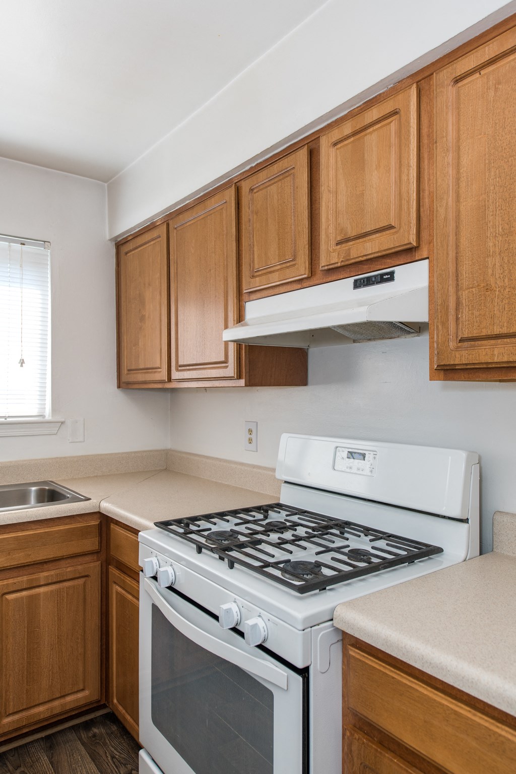 an empty kitchen with a stove and a sink
