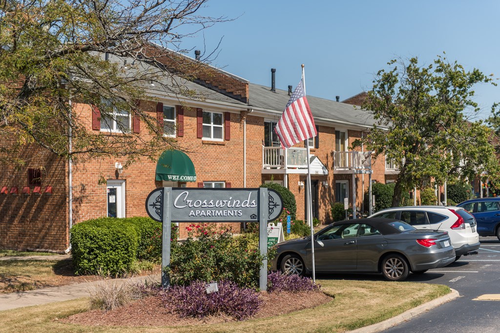 the front of a crossroads apartments building with cars parked in front