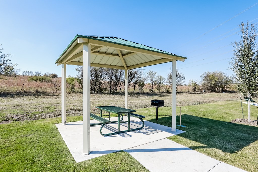 a picnic pavilion with a picnic table and a grill