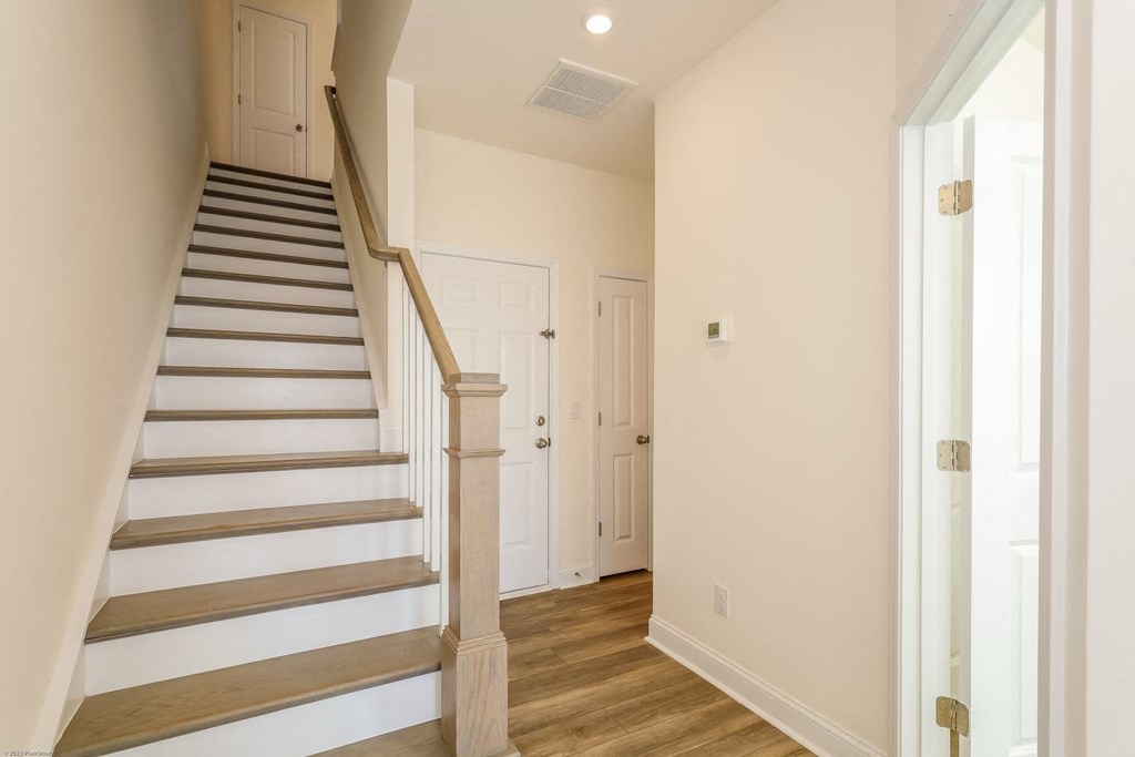 a view of a staircase in a home with white walls and wood floors