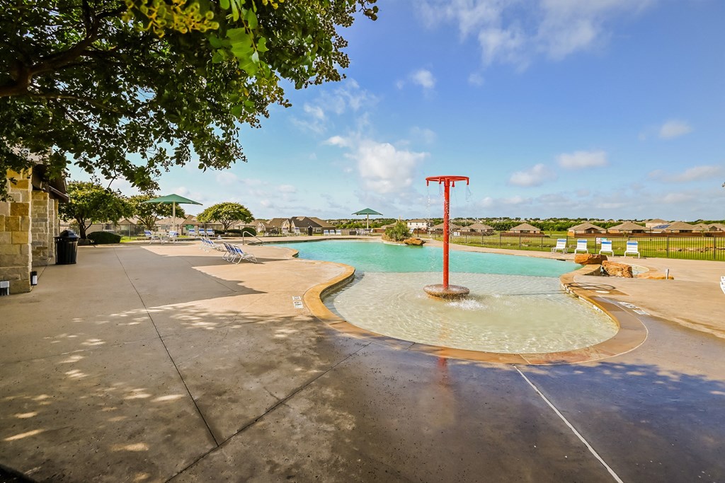 a swimming pool with a red pole in the water and a tree