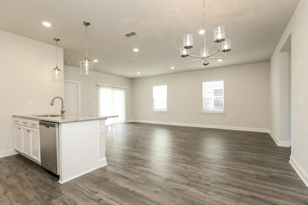 an empty kitchen and living room with a sink and a counter top