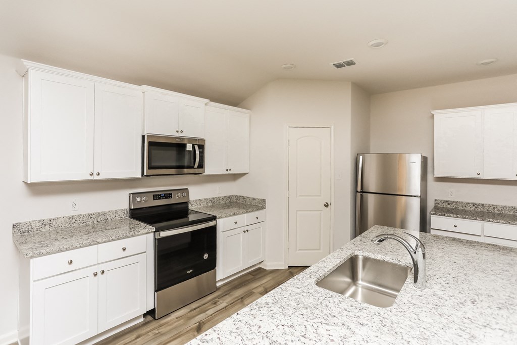 a kitchen with white cabinets and stainless steel appliances