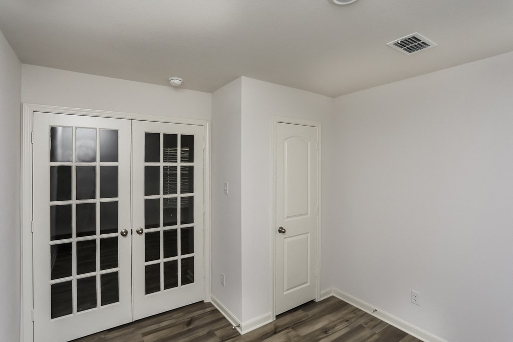 an empty room with two doors and a window