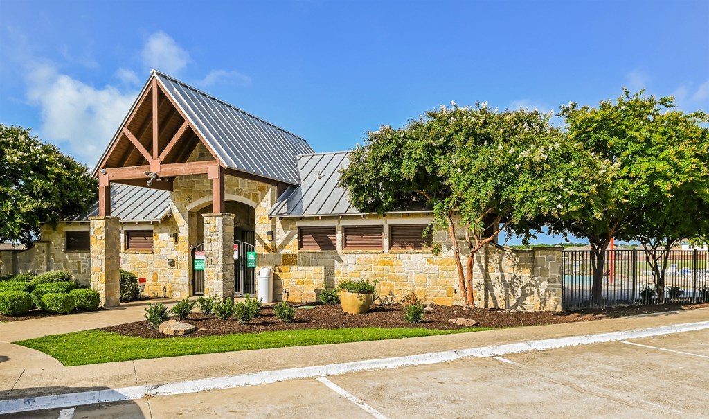 the front of a brick house with a tree and a driveway