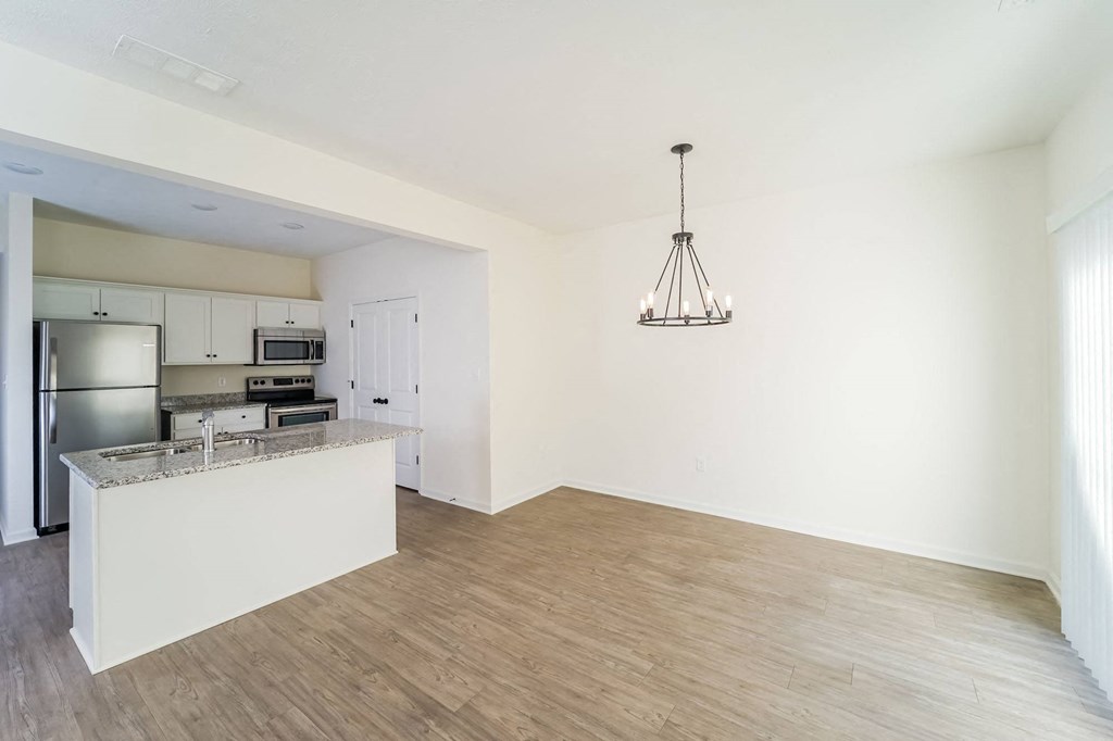 an empty living room and kitchen with a counter top
