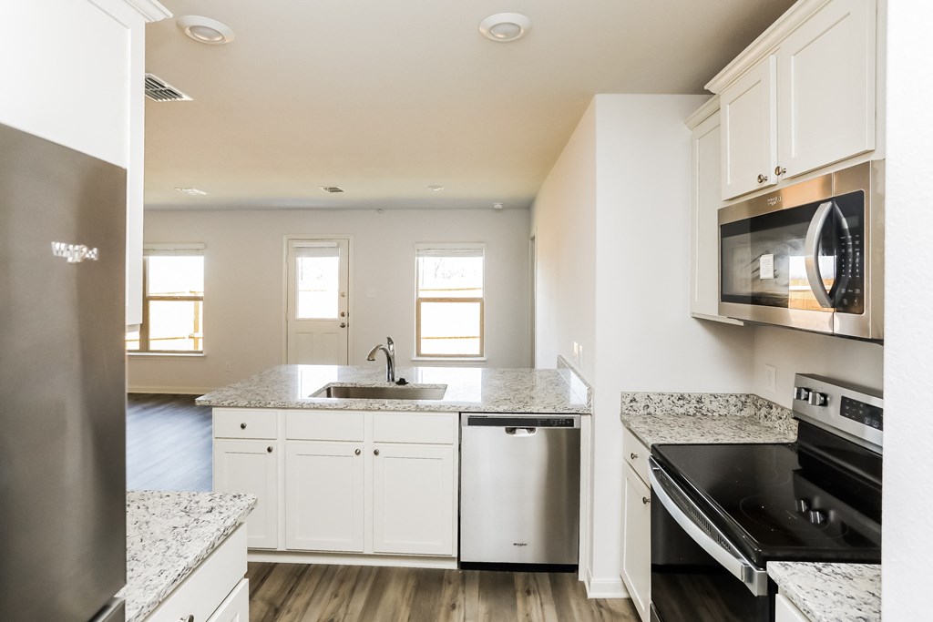 a kitchen with white cabinets and black appliances and a sink