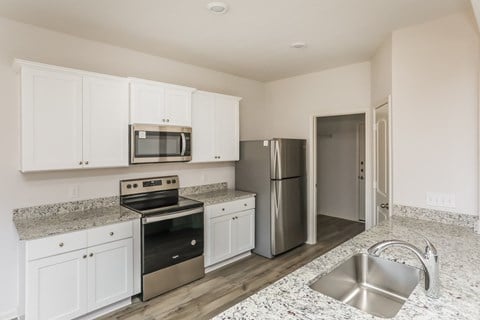 a kitchen with white cabinets and stainless steel appliances