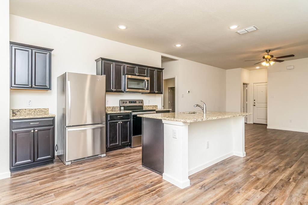 an empty kitchen with stainless steel appliances and a counter top