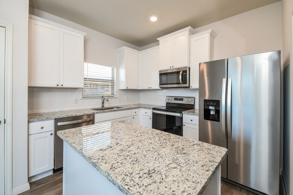  3 Bedroom single family homes for rent in fort Worth, TX- Oak Ridge - An interior shot of the kitchen, featuring stainless steel appliances, white cabinetry, and an island