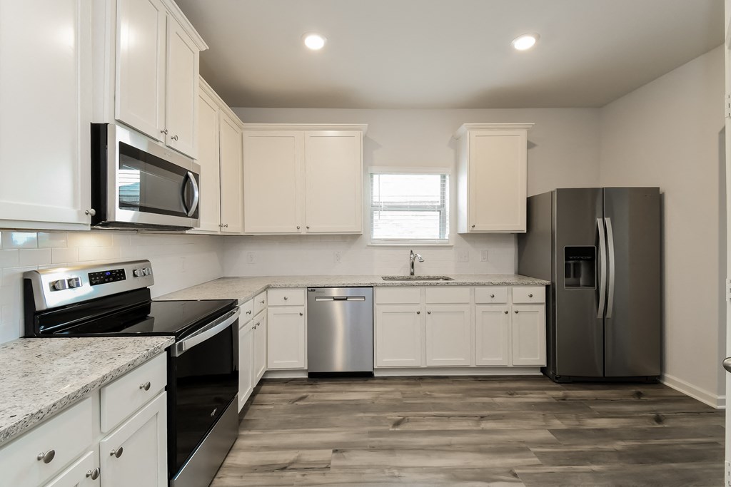 a kitchen with white cabinets and stainless steel appliances