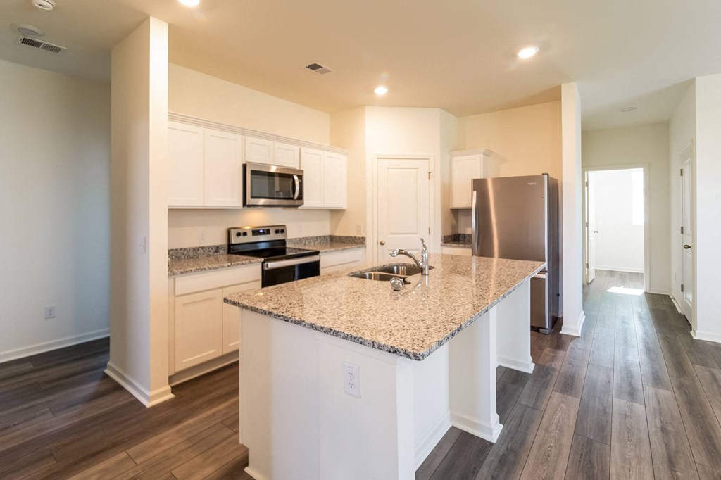 a kitchen with white cabinets and a granite counter top