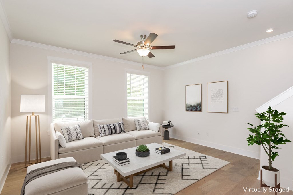 a living room with white walls and a ceiling fan