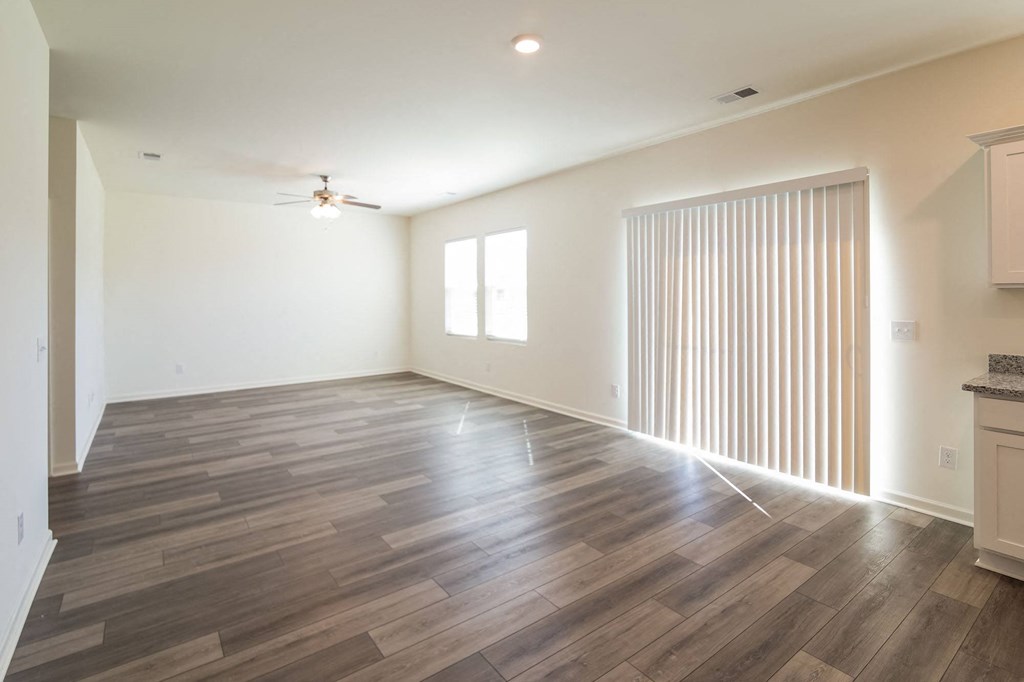 the living room and dining room of a new home with wood floors and a sliding