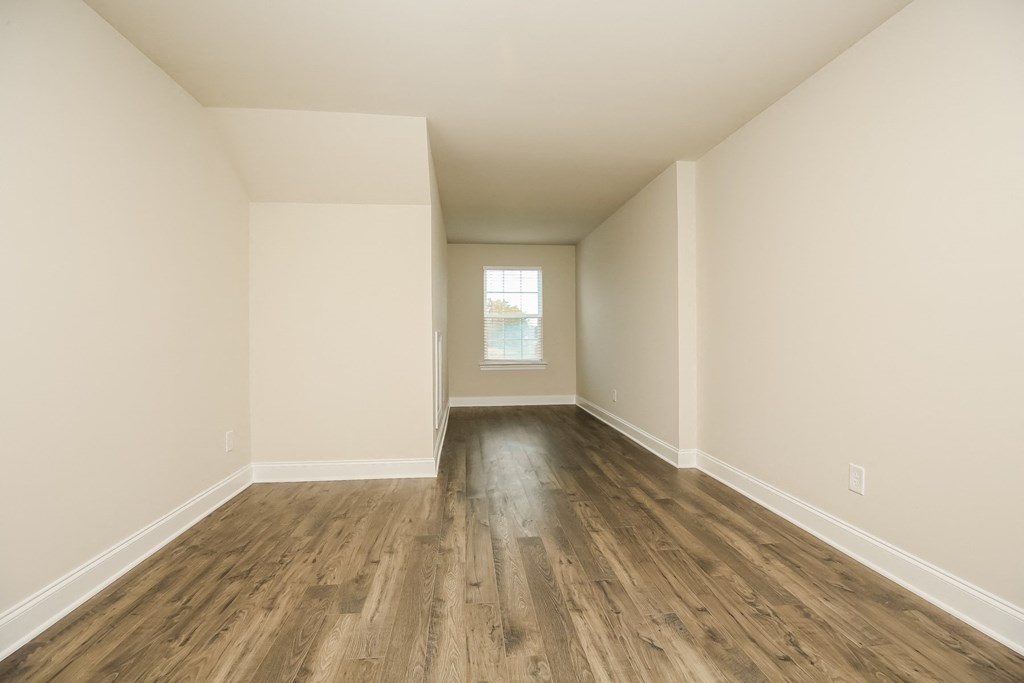 an empty room with white walls and wood floors