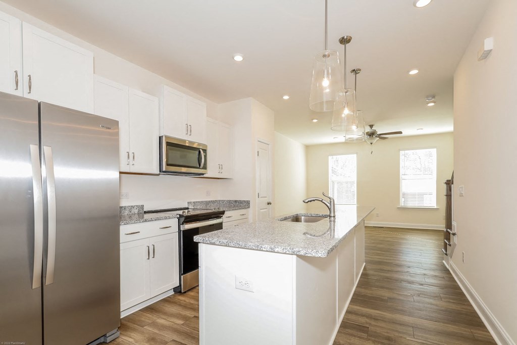 a kitchen with white cabinets and stainless steel appliances