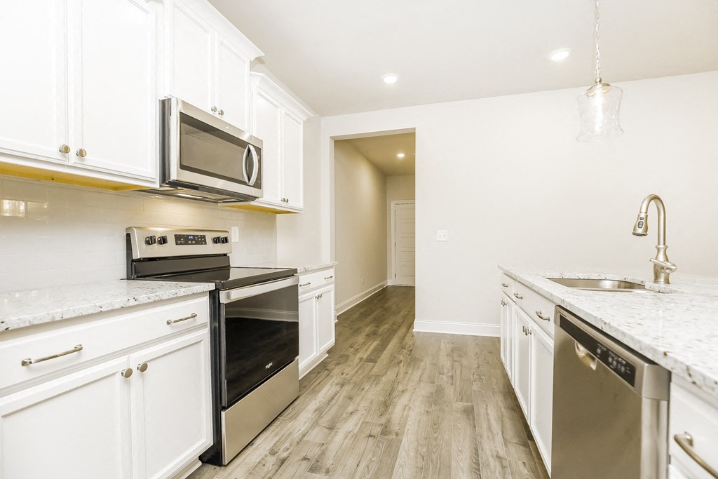 a kitchen with white cabinets and stainless steel appliances