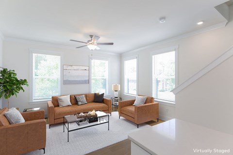 a living room with couches and a ceiling fan