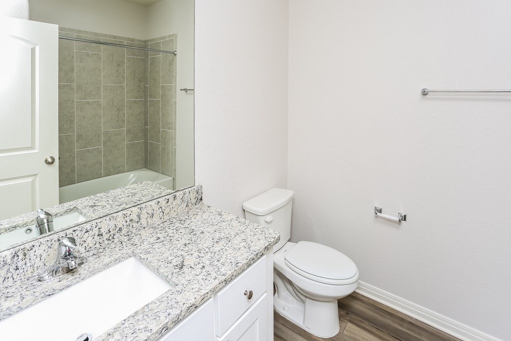 a bathroom with a toilet and a sink and a shower