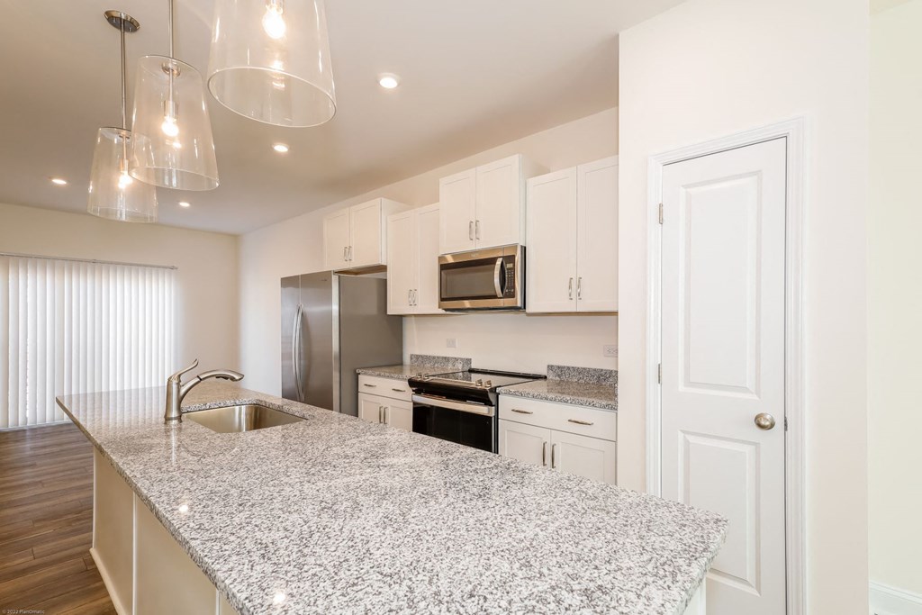 a kitchen with granite countertops and white cabinets